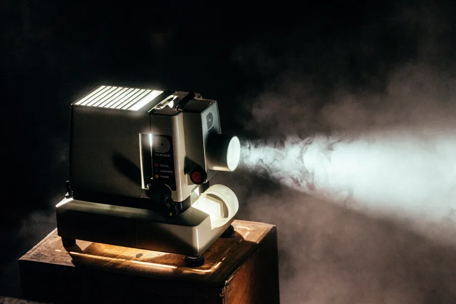 Projecteur de cinéma ancien diffusant un faisceau lumineux dans une salle sombre